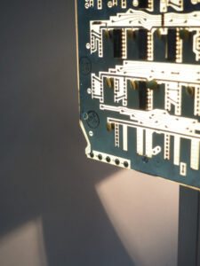 Vue côté lampe aspect argenté allumée acier brossé et cartes électroniques avec ses reflets