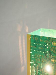 Vue dessus lampe verte et dorée allumée et réalisée avec des circuits imprimés. Piètement laitonné 4 pieds avec ses reflets