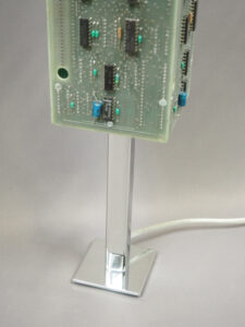 Socle lampe verte et argentée éteinte réalisée avec des cartes électroniques et un piètement en acier chromé