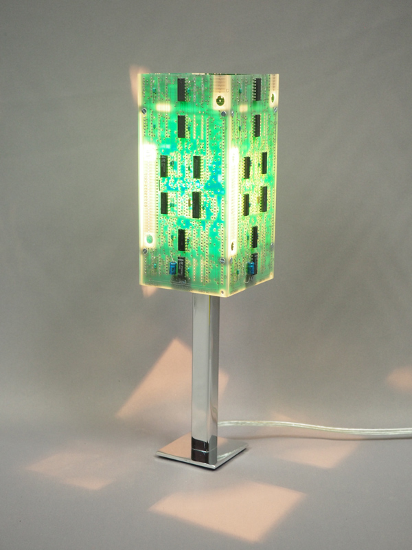 Green and silver lighted lamp made with electronic cards and a chrome steel base with its reflections