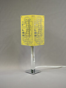 Lampe jaune et argentée éteinte réalisée avec des cartes électroniques et un piètement en acier chromé