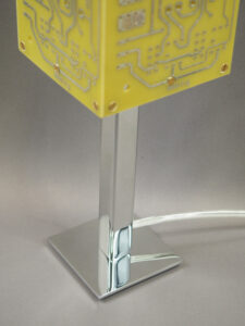 Socle lampe jaune et argentée éteinte réalisée avec des cartes électroniques et un piètement en acier chromé